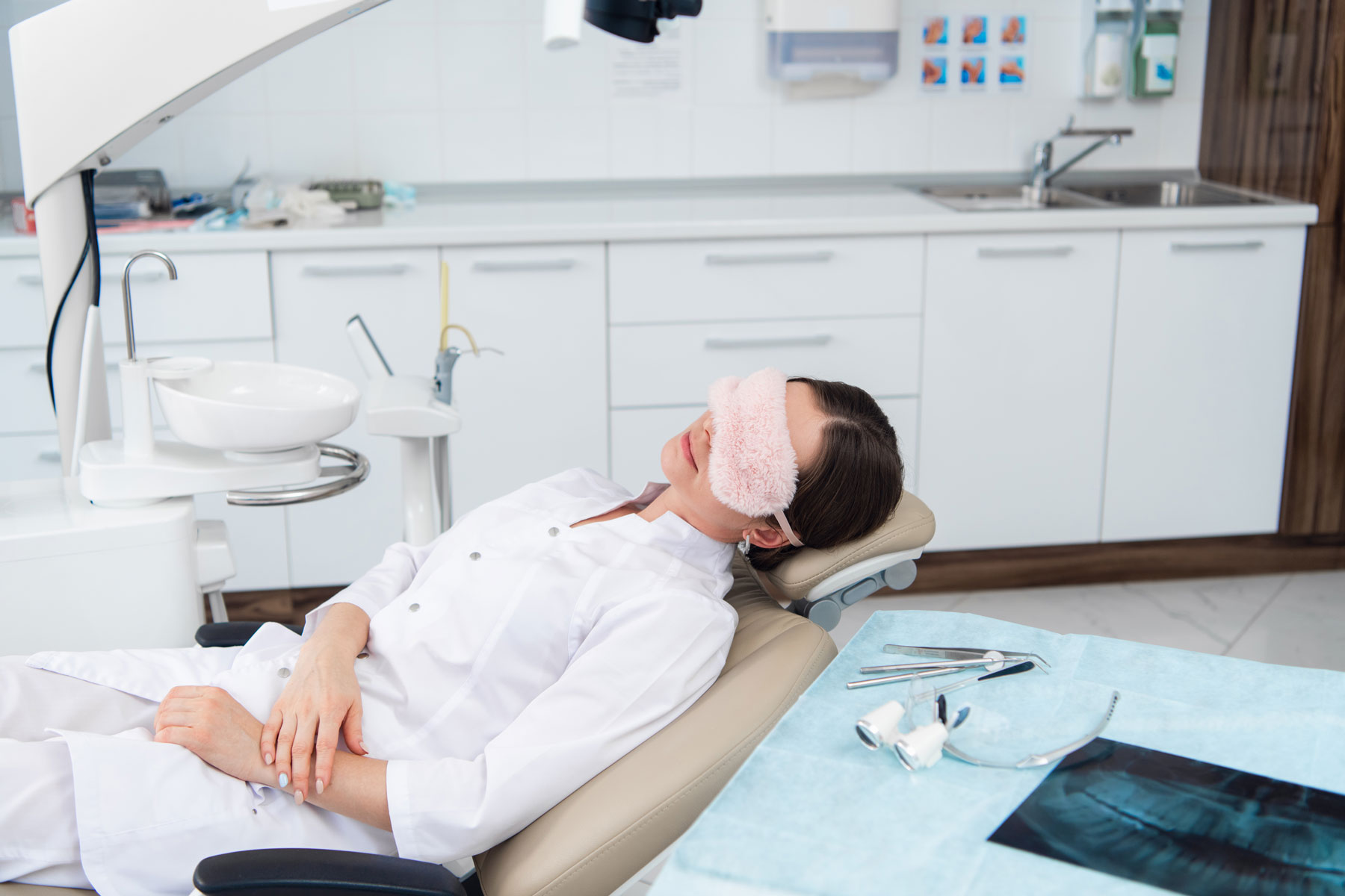 Patientin liegt auf Zahnarztstuhl und schläft